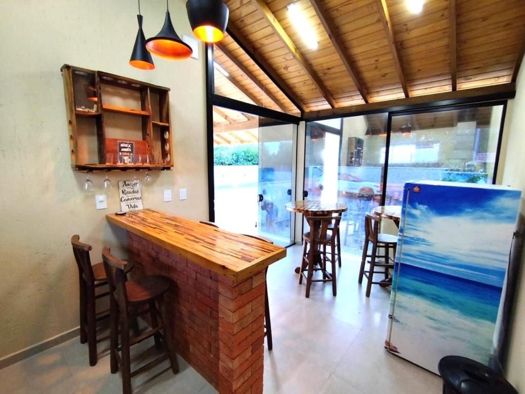 een bar in een restaurant met een tafel en stoelen bij Morada Guarda Paradise in Guarda do Embaú