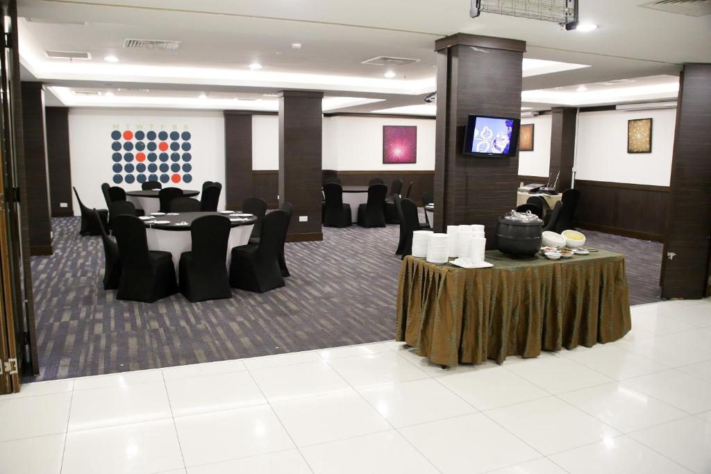 a conference room with tables and chairs and a television at Badi'ah Hotel in Bandar Seri Begawan