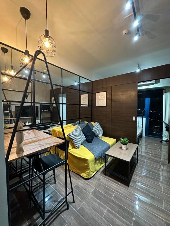 a bedroom with a yellow bed and a table at Air Residences Airbnb in Manila