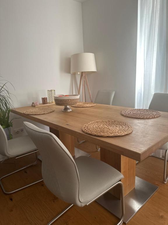 a wooden table with chairs and a lamp on it at Appartement Lena in Linz