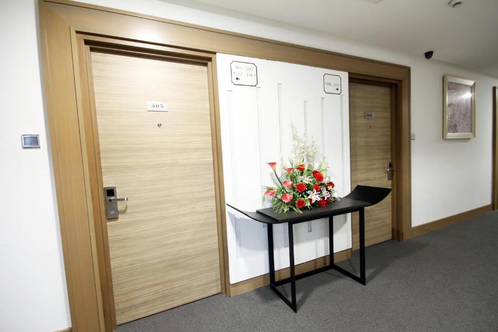 a hallway with a door and a table with flowers on it at Badi'ah Hotel in Bandar Seri Begawan