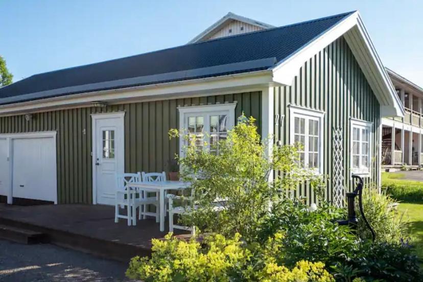 een groen gebouw met een picknicktafel ervoor bij Lilla gröna huset på gården in Härnösand