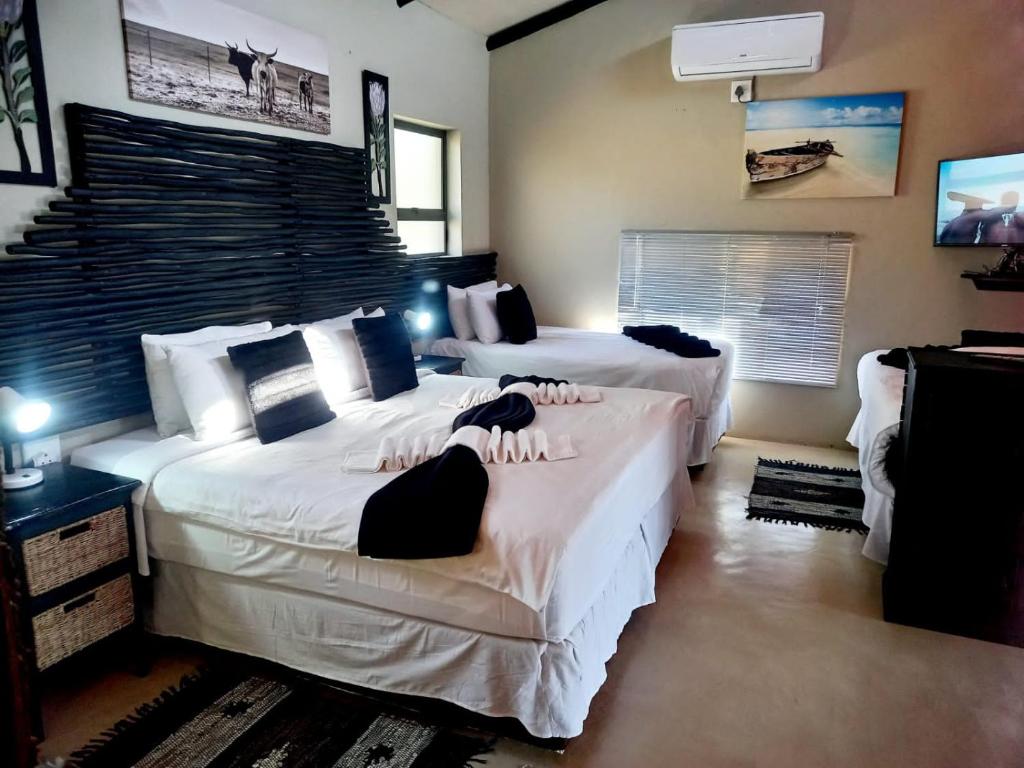 a bedroom with two beds with white sheets at shiringa holiday home in Marloth Park