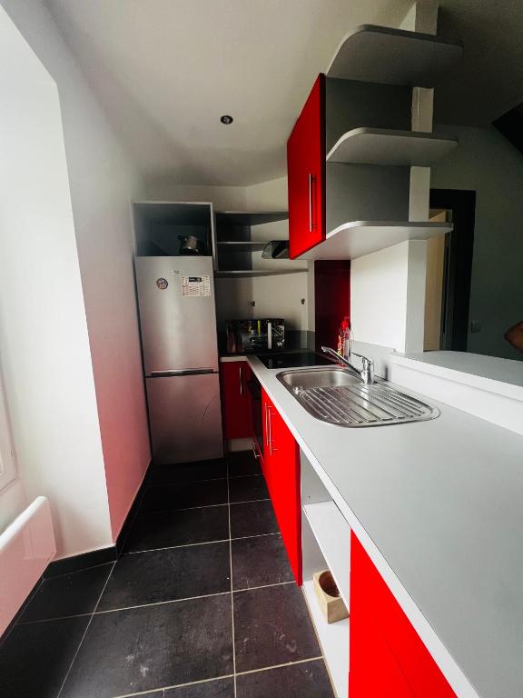 a kitchen with red and white cabinets and a refrigerator at Charmant duplex à BILLÈRE aux portes de Pau in Billère