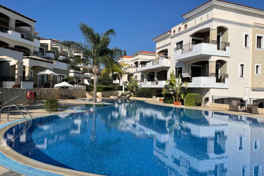 ein großer Pool vor einigen Apartmentgebäuden in der Unterkunft Eleona's Royal Gardens By Yiota - Luxury 2 Bed Apartment in Exclusive Complex in Peyia