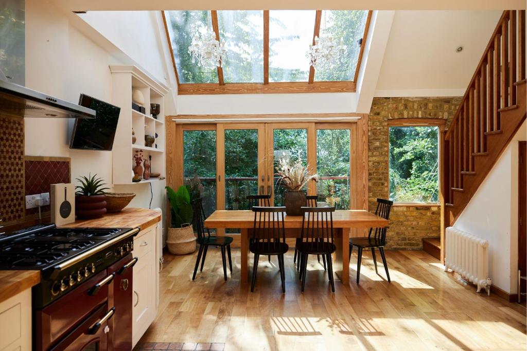 uma cozinha com mesa e cadeiras e uma grande janela em The Hampstead Wonder - Spacious 4BDR House with Balcony em Londres