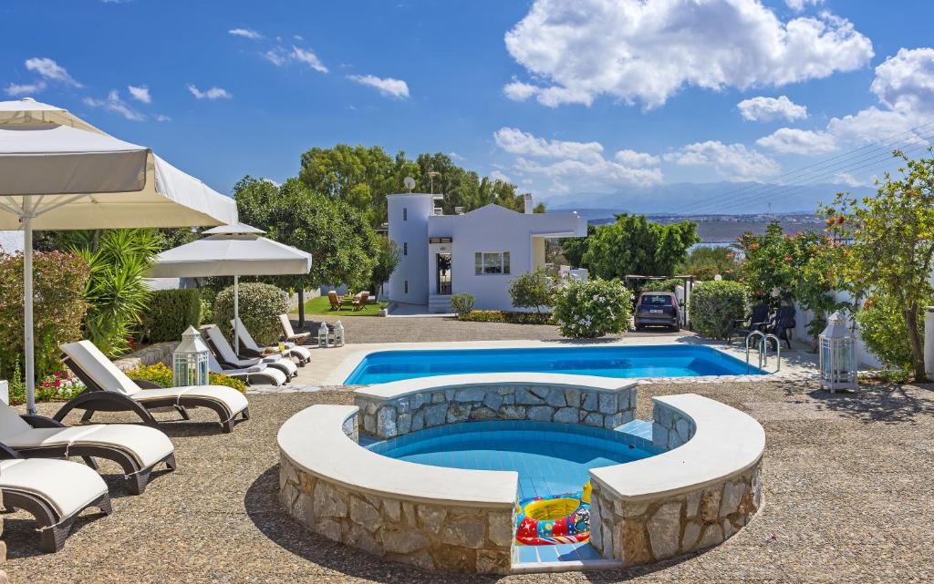 a backyard with a pool and chairs and a house at Villa Plumeria Flower in Tersanas