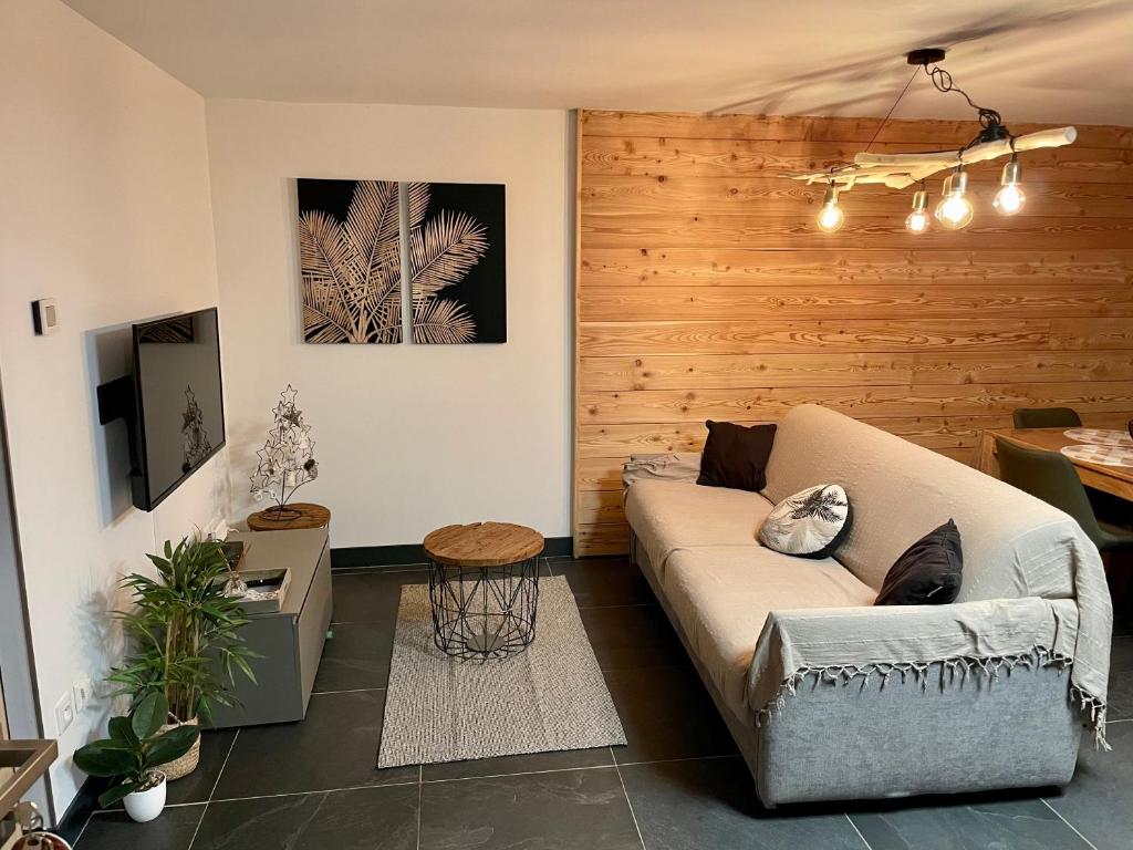 sala de estar con sofá y mesa en Studio neuf et chaleureux, en Vars