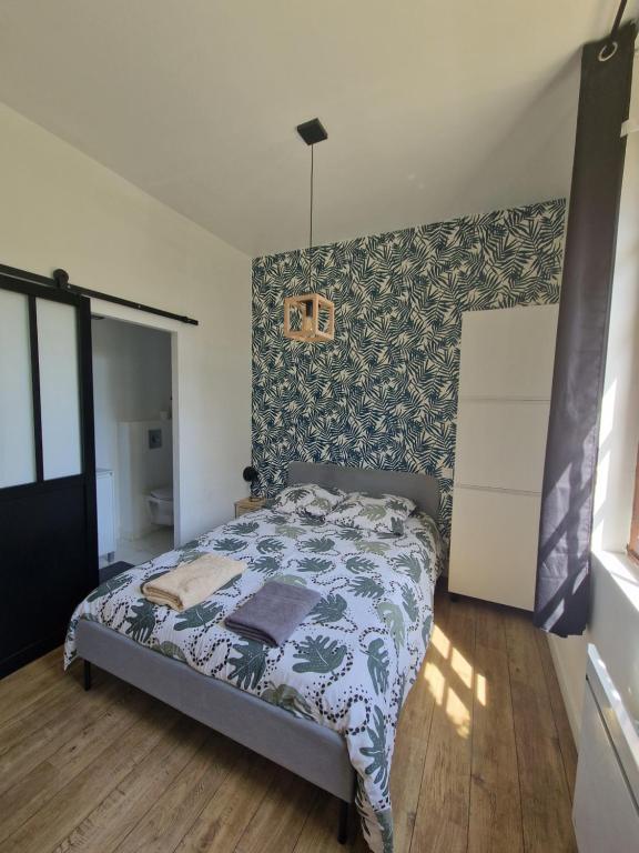 - une chambre dotée d'un lit avec un mur à motifs dans l'établissement T1, à Toulouse