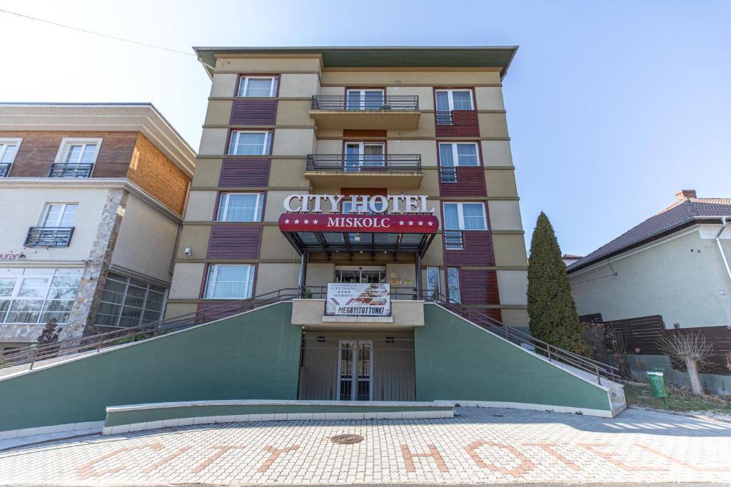 een gebouw met een bord dat stadshotel leest bij City Hotel Miskolc in Miskolc
