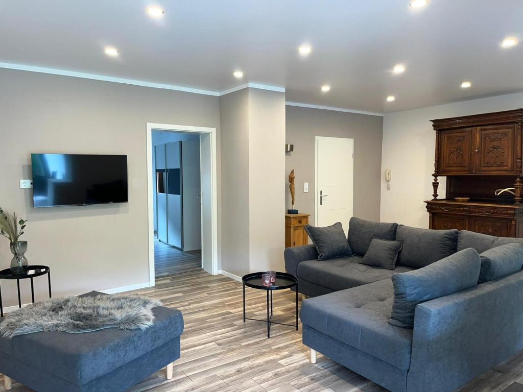 a living room with two couches and a flat screen tv at Ferienwohnung Göttert – Haus Erika in Beckingen