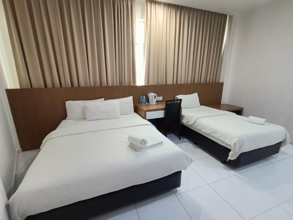 Postel nebo postele na pokoji v ubytování Hotel Wawasan