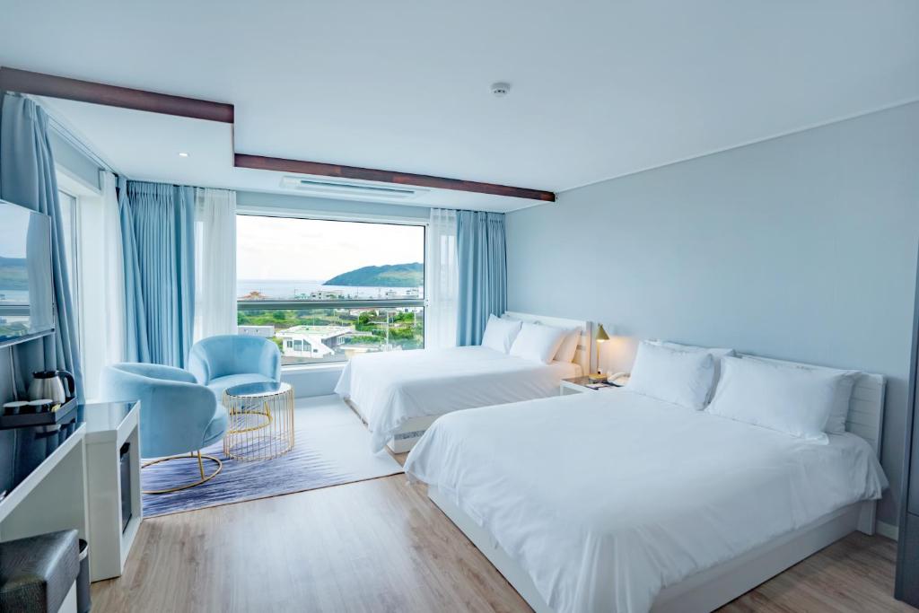 Postel nebo postele na pokoji v ubytování Hotel Sweet Castle Jeju Hamdeok