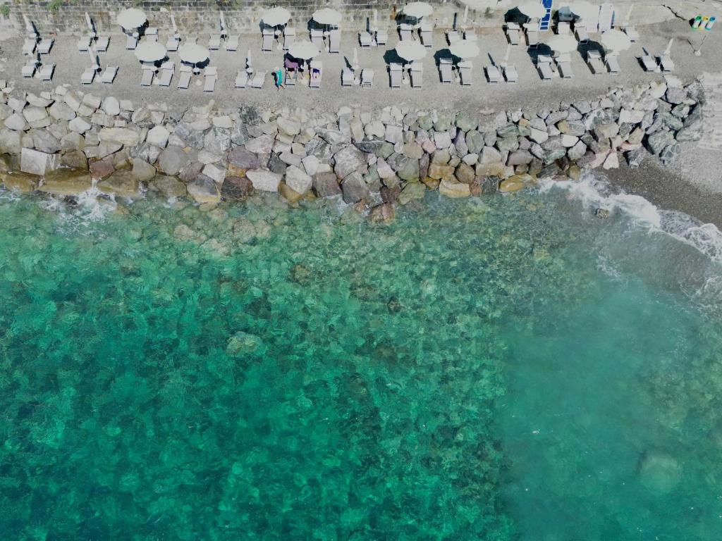 - une vue aérienne sur une piscine d'eau entourée de chaises dans l'établissement Villaggio Smeraldo, à Moneglia