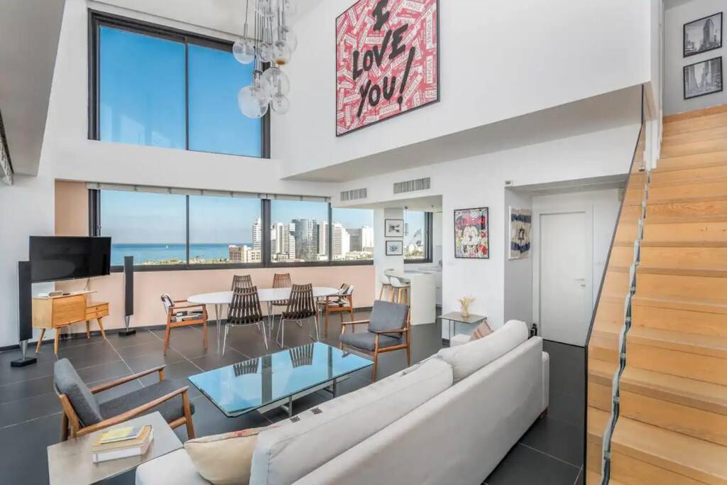 a living room with a couch and a table at Moderne 3BR - Vue mer in Tel Aviv