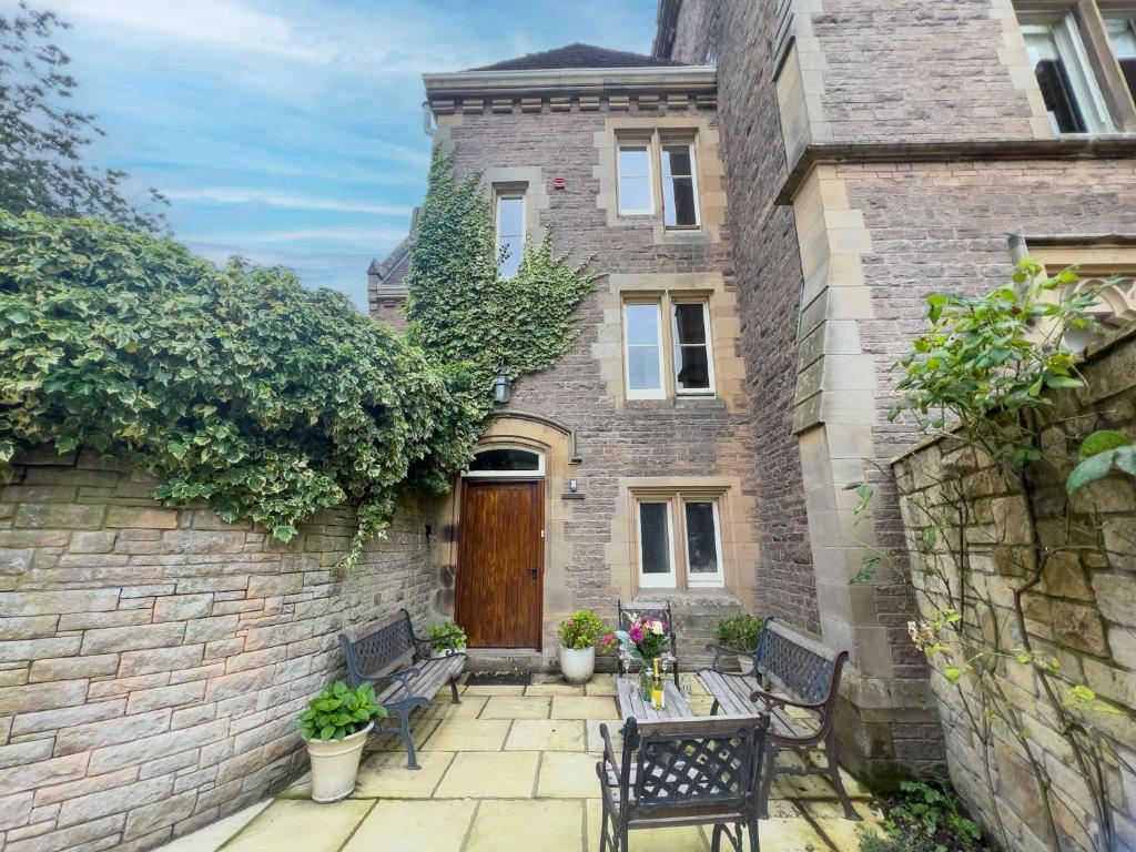 a brick house with two benches and a wooden door at Geltsdale Wing, Wetheral in Wetheral