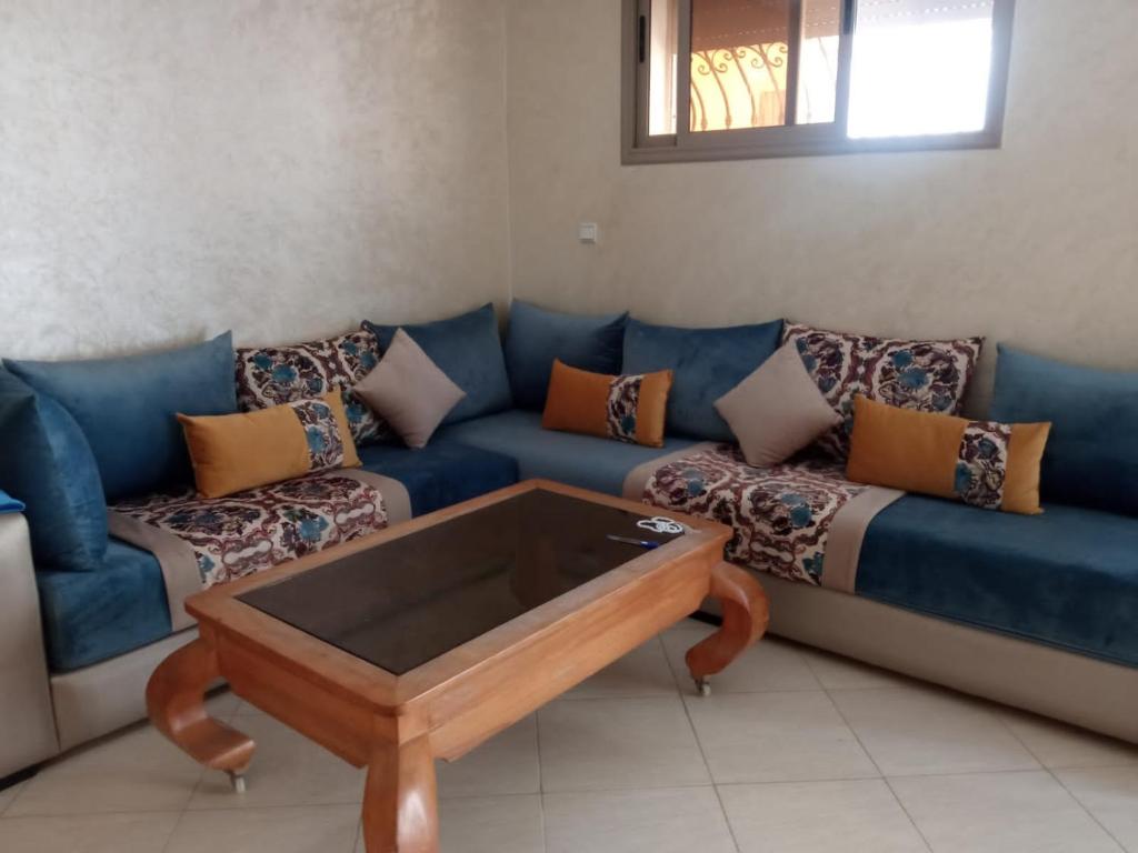 a living room with a blue couch and a coffee table at شقة فونتي العليا in Agadir