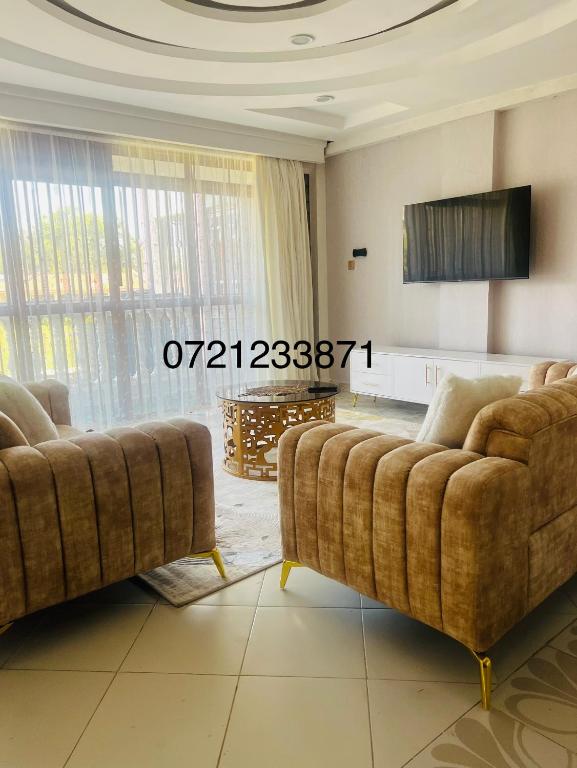 un soggiorno con 2 divani e una TV di Regency Homes a Eldoret