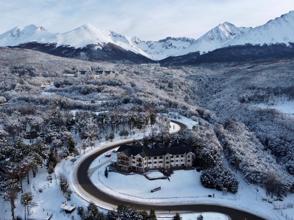 z powietrza widok na ośrodek z pokrytymi śniegiem górami w obiekcie Altos Ushuaia Hotel & Resto w mieście Ushuaia