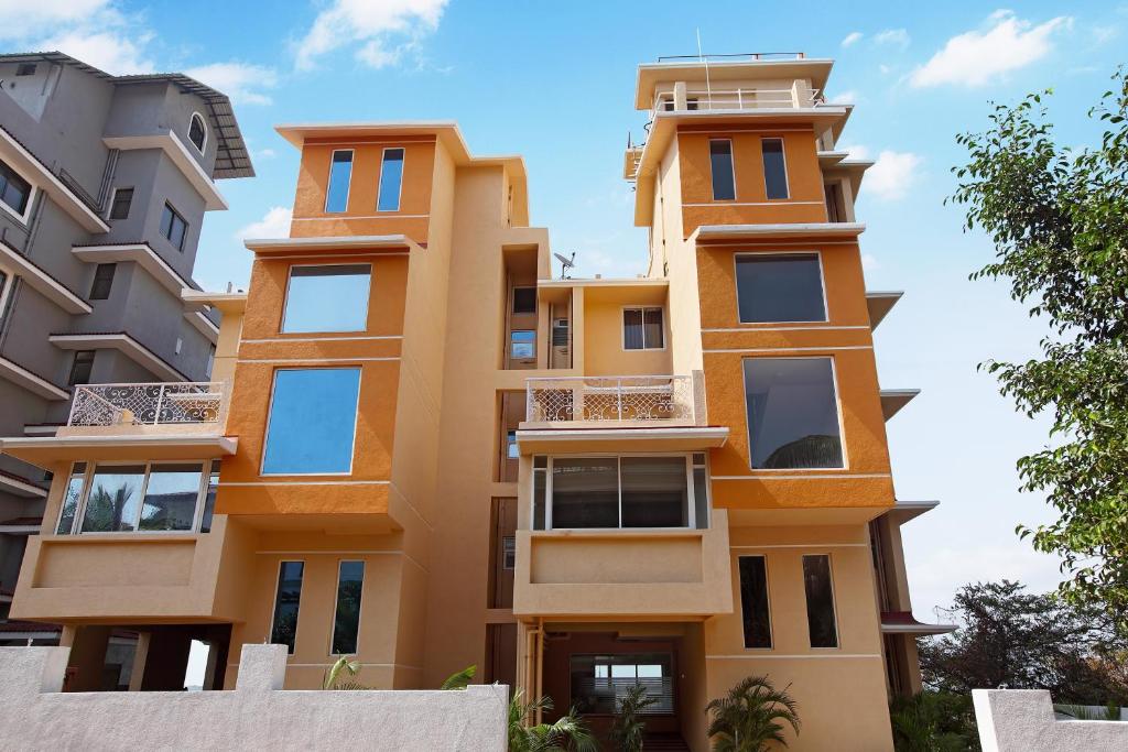 a tall yellow building with many windows at Athome Comforts in Panaji