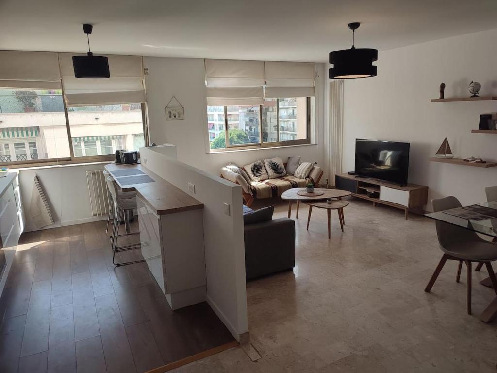 ein Wohnzimmer mit einer Küche und ein Wohnzimmer mit einem Sofa in der Unterkunft NICE ÉTOILE in Nizza