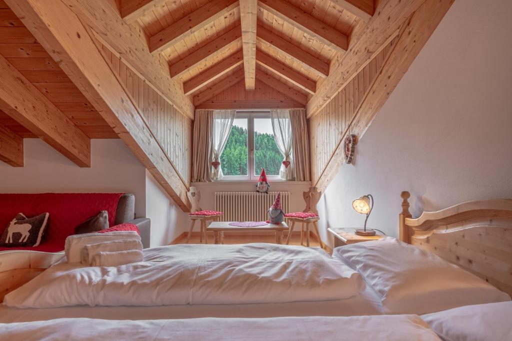 um quarto com 2 camas num quarto com tectos em madeira em Residence Stella em Folgaria