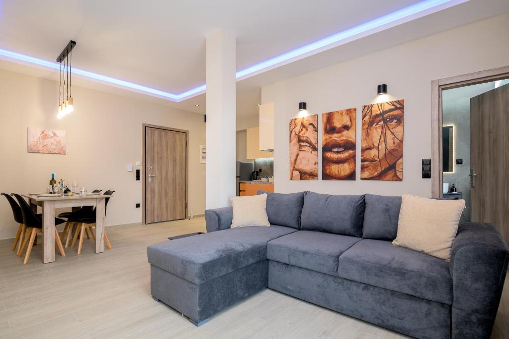 a living room with a blue couch and a table at ALEXANDRA'S COMFORT CITY APARTMENT in Alexandroupoli