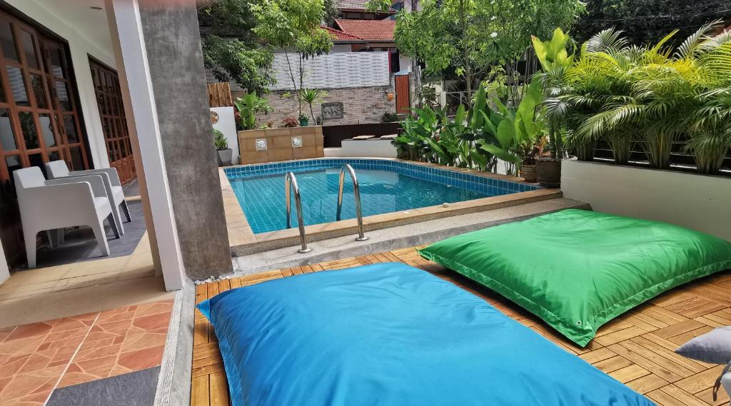 two pillows sitting next to a swimming pool at DB Studios Samui in Lamai