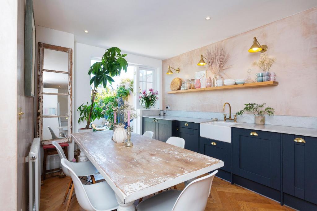 a kitchen with blue cabinets and a table with chairs at Veeve - True Romance in London