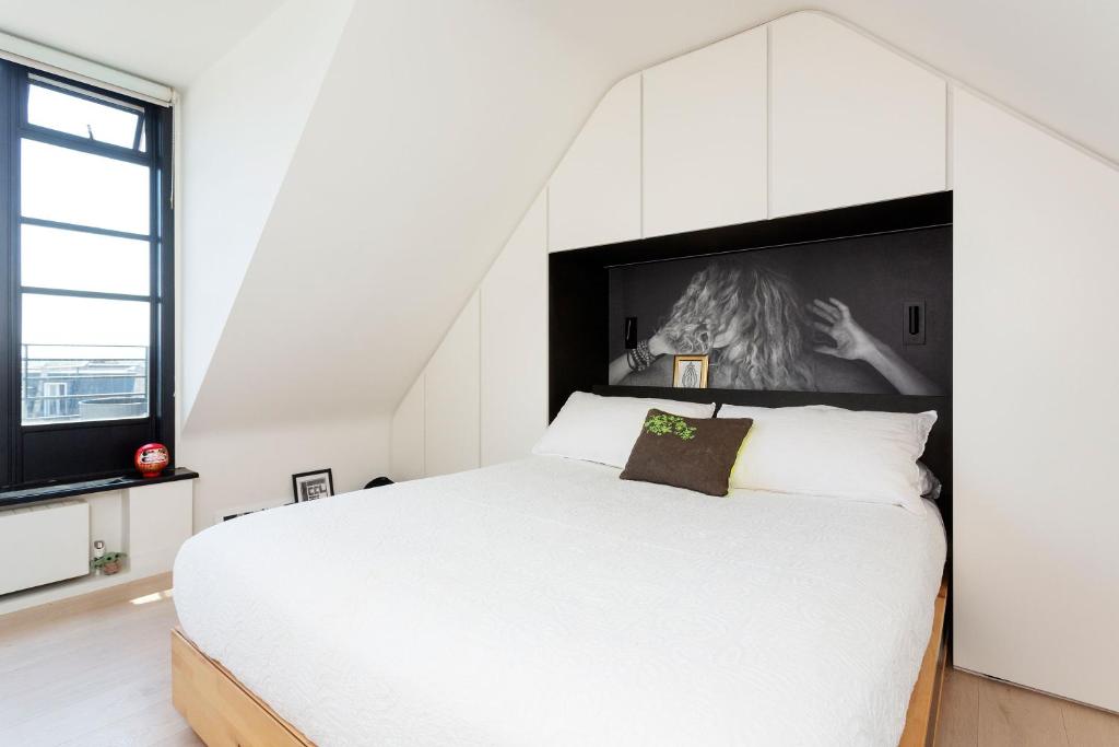 a bedroom with a white bed and a large window at Veeve - Celestial Loft in London