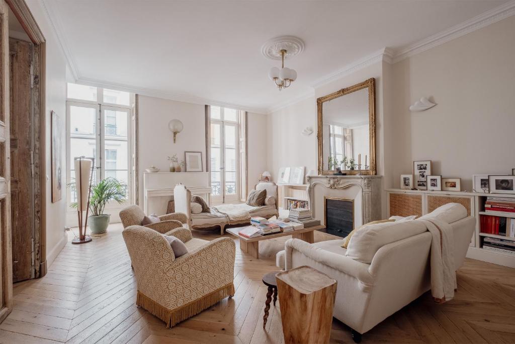 a living room with white furniture and a fireplace at Veeve - Poetic Harmony in Paris