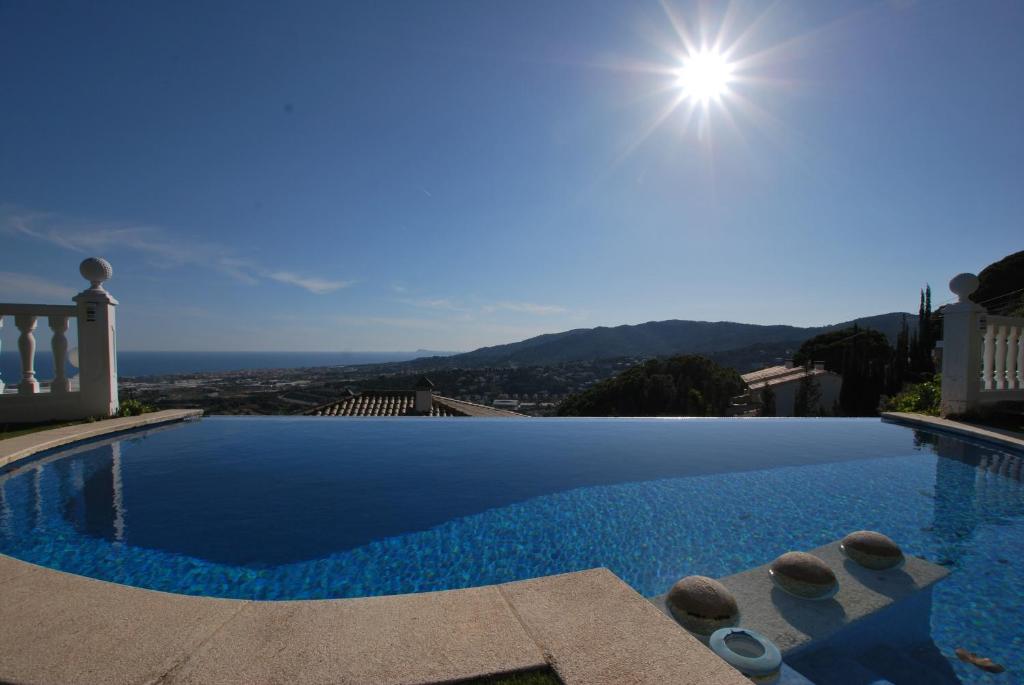 a large swimming pool with a view of the ocean at Sunny house in Cabrils