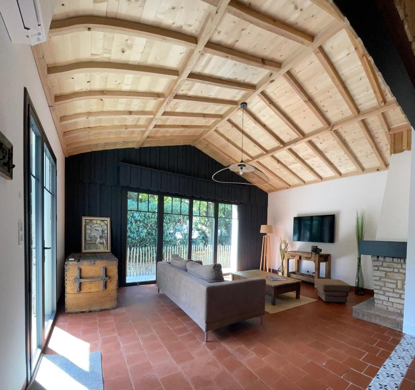 un salon avec un canapé et une cheminée dans l'établissement Maison La Plage 26, à Gujan-Mestras