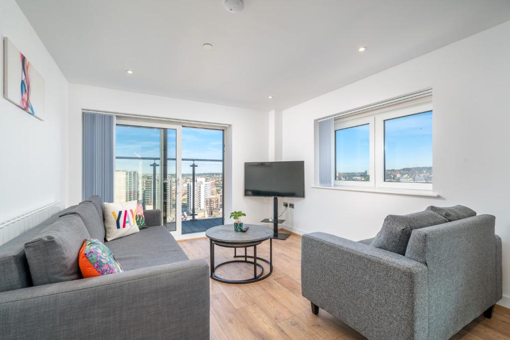 a living room with two couches and a tv at Skyvillion - London River Thames Top Floor Apartments by Woolwich Ferry, Mins to London ExCel, O2 Arena , London City Airport with Parking in London