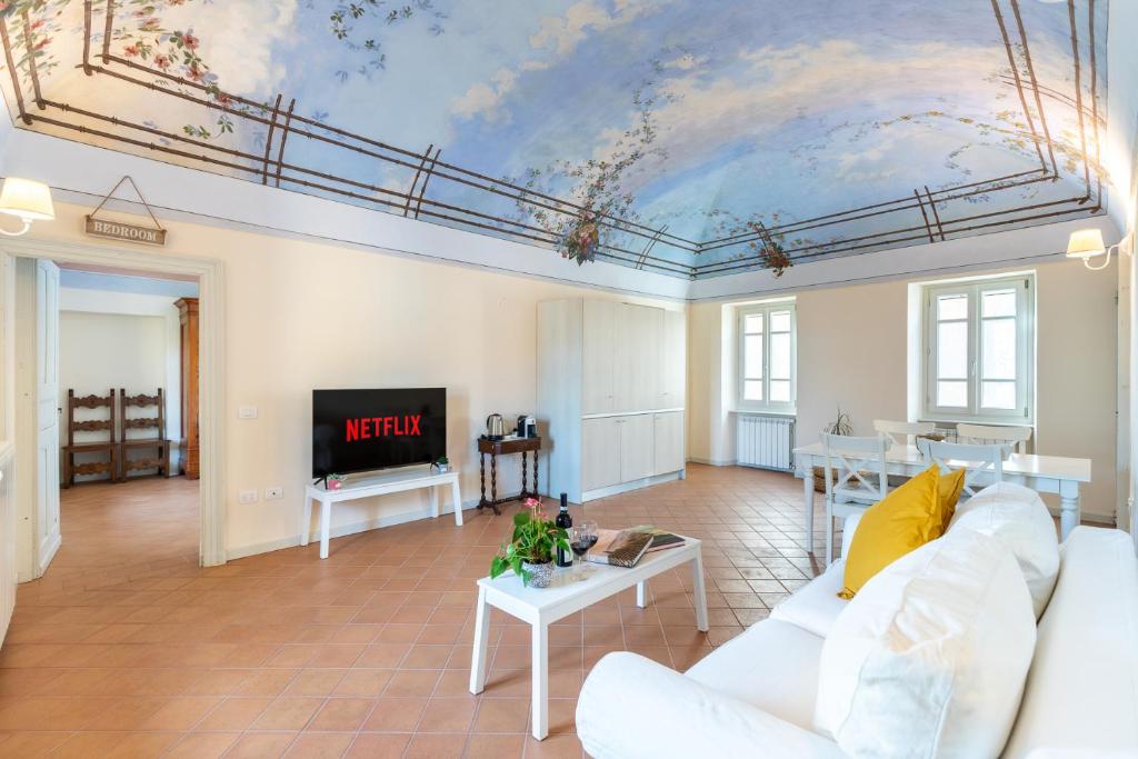 Borgo Alfieri - Elegant suites with stunning view في Magliano Alfieri: غرفة معيشة بسقف عليها لوحة