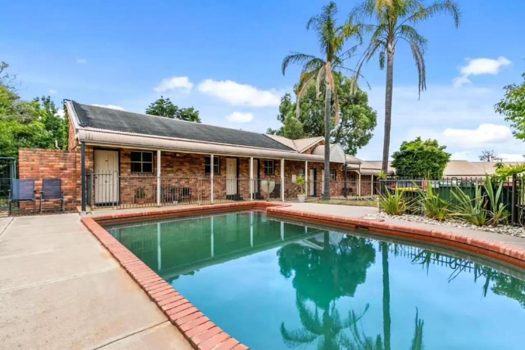 a house with a swimming pool in front of a house at Comfort Inn Greensborough in Melbourne