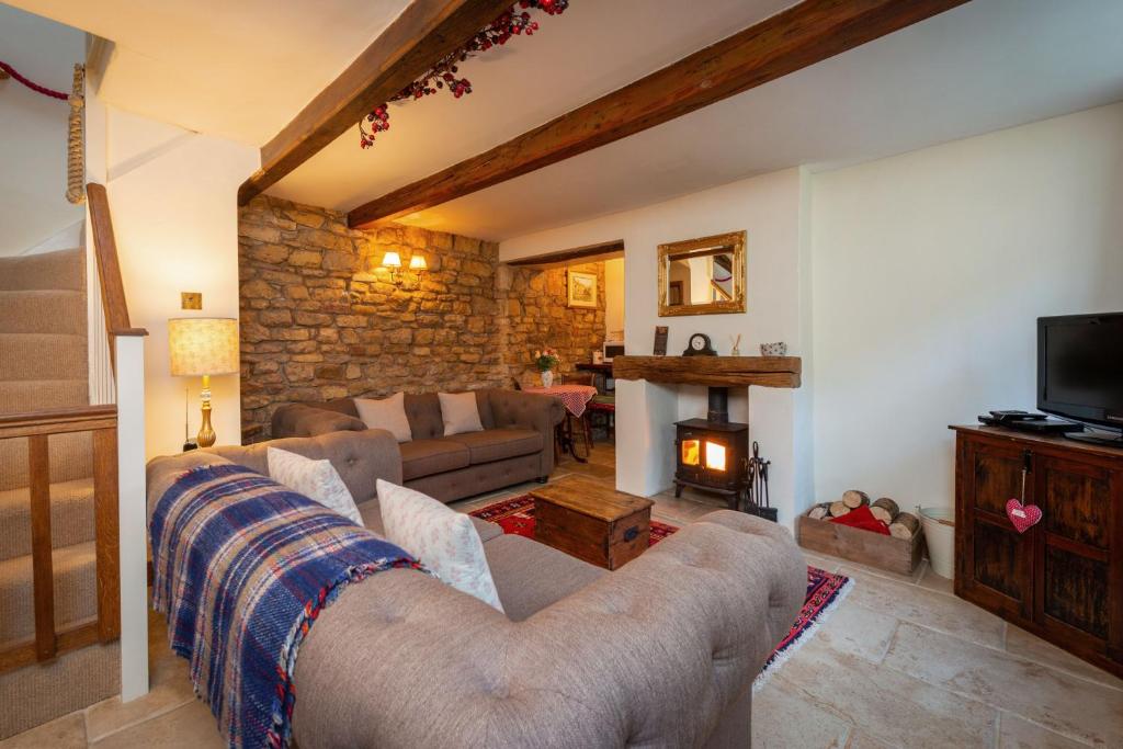 a living room with a couch and a fireplace at The Honeypot in Chipping Campden