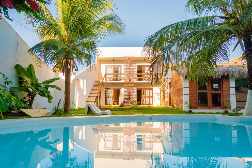 una casa con palmeras y piscina en POUSADA VILLAGE KITE en Camocim