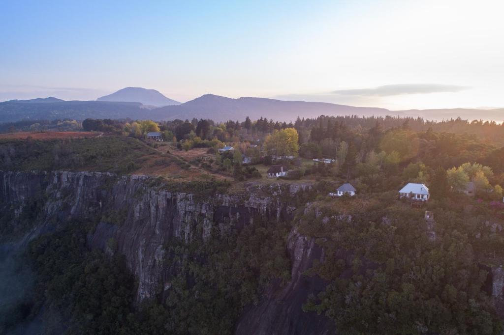 uma vista aérea de uma montanha com árvores e casas em The Edge Mountain Retreat em Hogsback