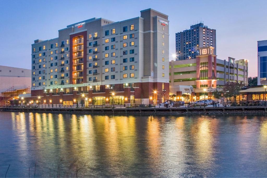 ein großes Gebäude neben einem Wasserkörper in der Unterkunft Courtyard by Marriott Gaithersburg Washingtonian Center in Gaithersburg