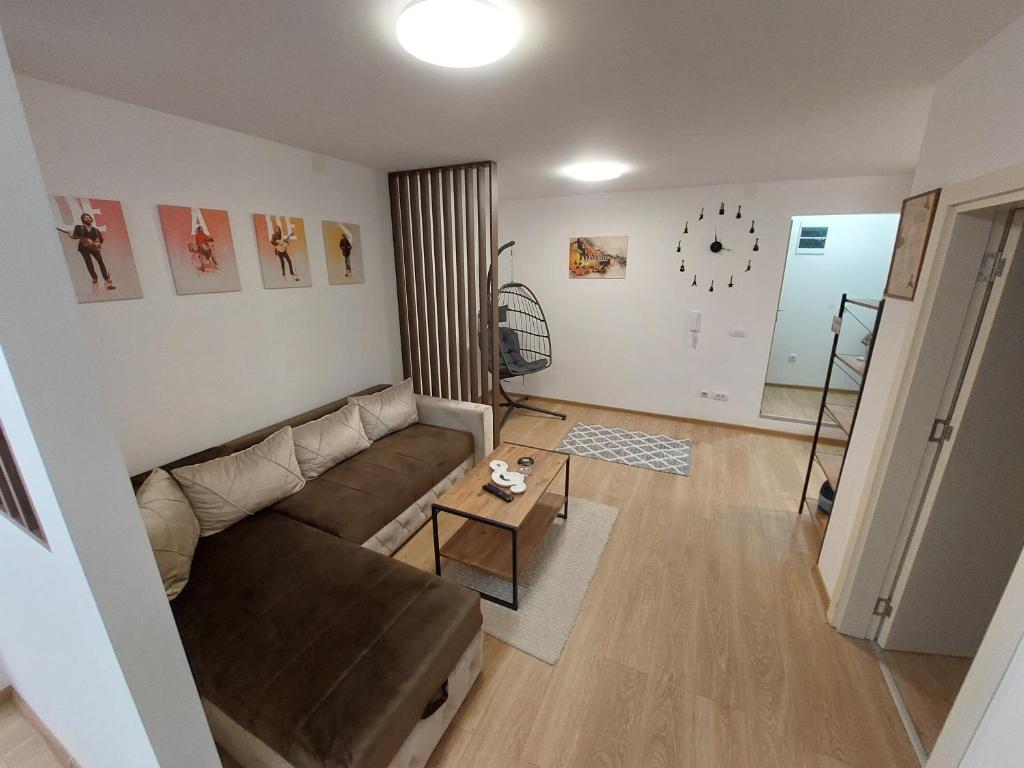 ein Wohnzimmer mit einem Sofa und einem Tisch in der Unterkunft Apartman Muzika Jagodina in Jagodina