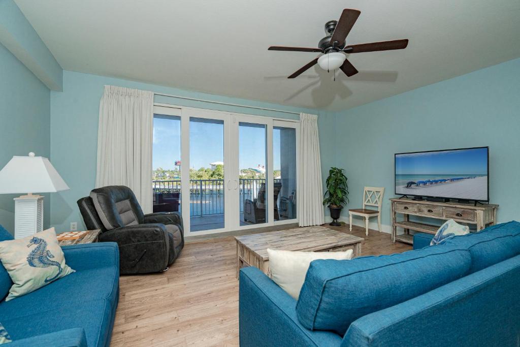 sala de estar con 2 sofás azules y TV de pantalla plana en Laketown Wharf #119 by Nautical Properties, en Panama City Beach