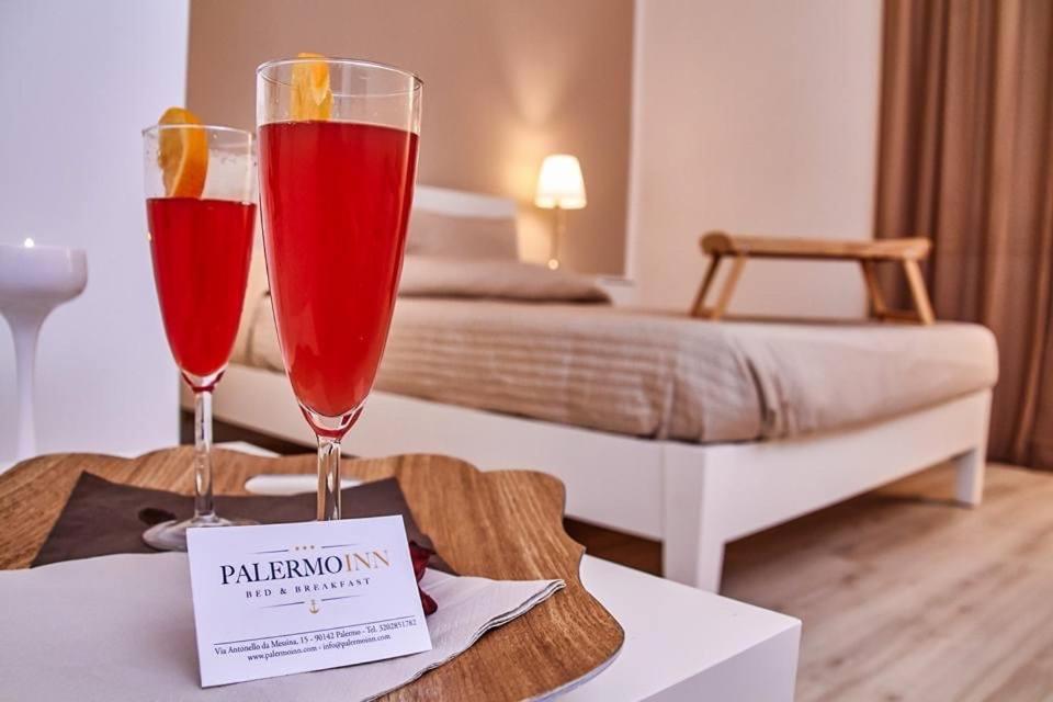 dois copos de vinho sentados numa mesa num quarto de hotel em Palermo Inn Apartment em Palermo
