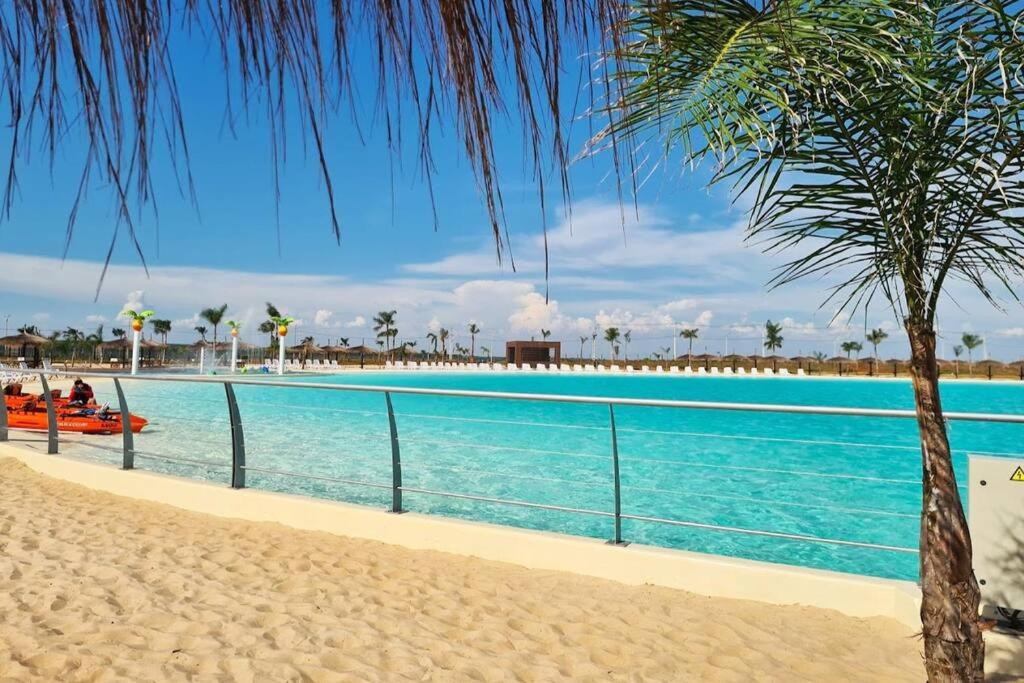 una piscina junto a una playa con palmeras en Paz y Armonía: Con Playa Privada en Hernandarias