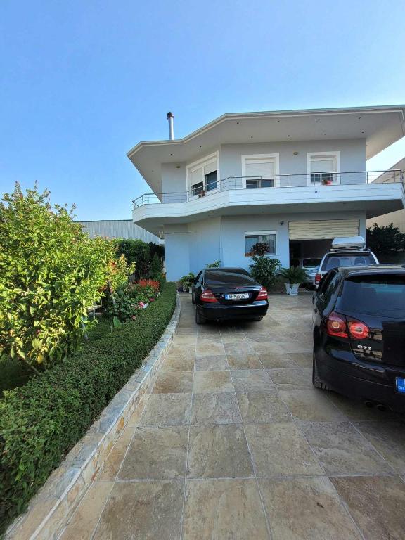 a house with two cars parked in front of it at Family Oasis in Vlorë