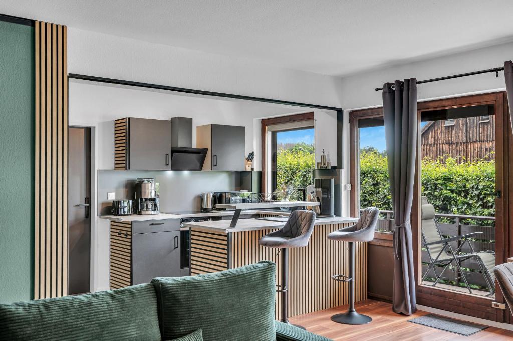 a kitchen and living room with a couch and chairs at STANMA Luchspartment ruhig und zentral mit großem Balkon und Parkplatz in Braunlage