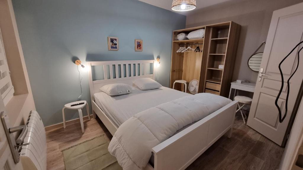 - une chambre avec un grand lit blanc et une table dans l'établissement Appartement RDC à 2 pas de la Plage et des commerces de BERCK PLAGE, à Berck-sur-Mer