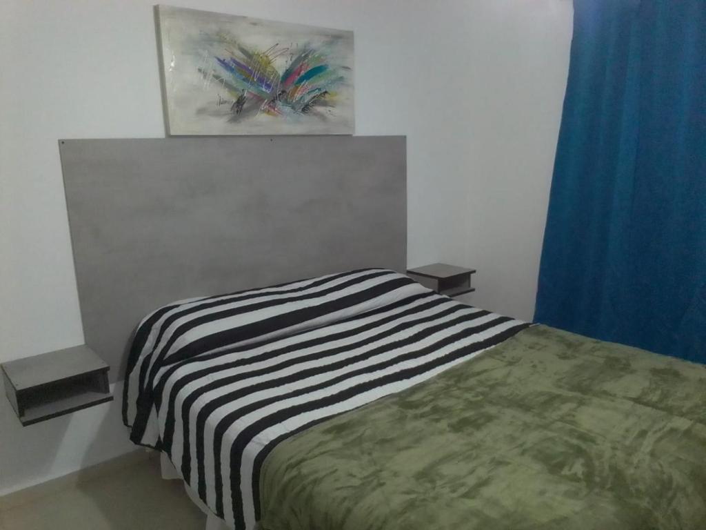 um quarto com uma cama e um quadro na parede em NEW YORK EN EDIFICIO MAFALFA COCHERA y Asador INCLUIDA em Río Cuarto