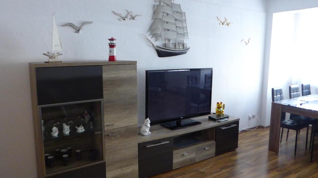 a living room with a television and a wooden entertainment center at Stralsunder in Stralsund