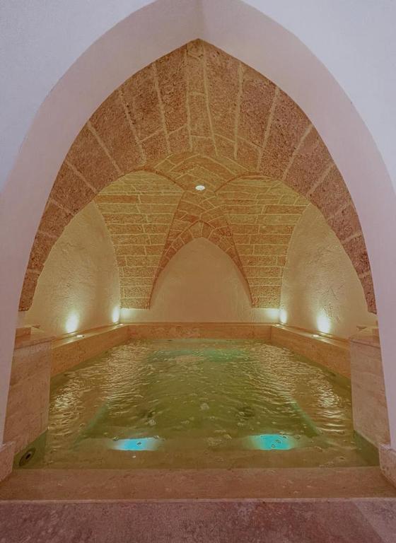 a large pool of water in a room with an arch at Zahra Superior Suite with private pool in Sannicola
